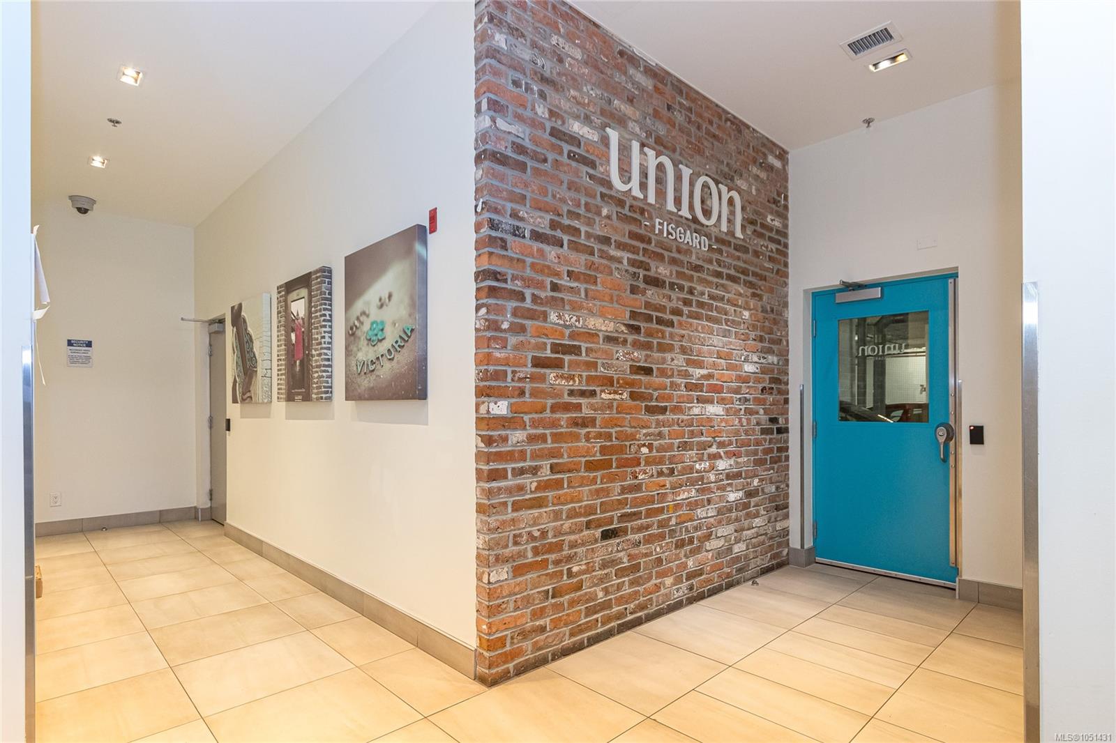 Union Fisgard lobby with a brick feature wall and turquoise entrance door.