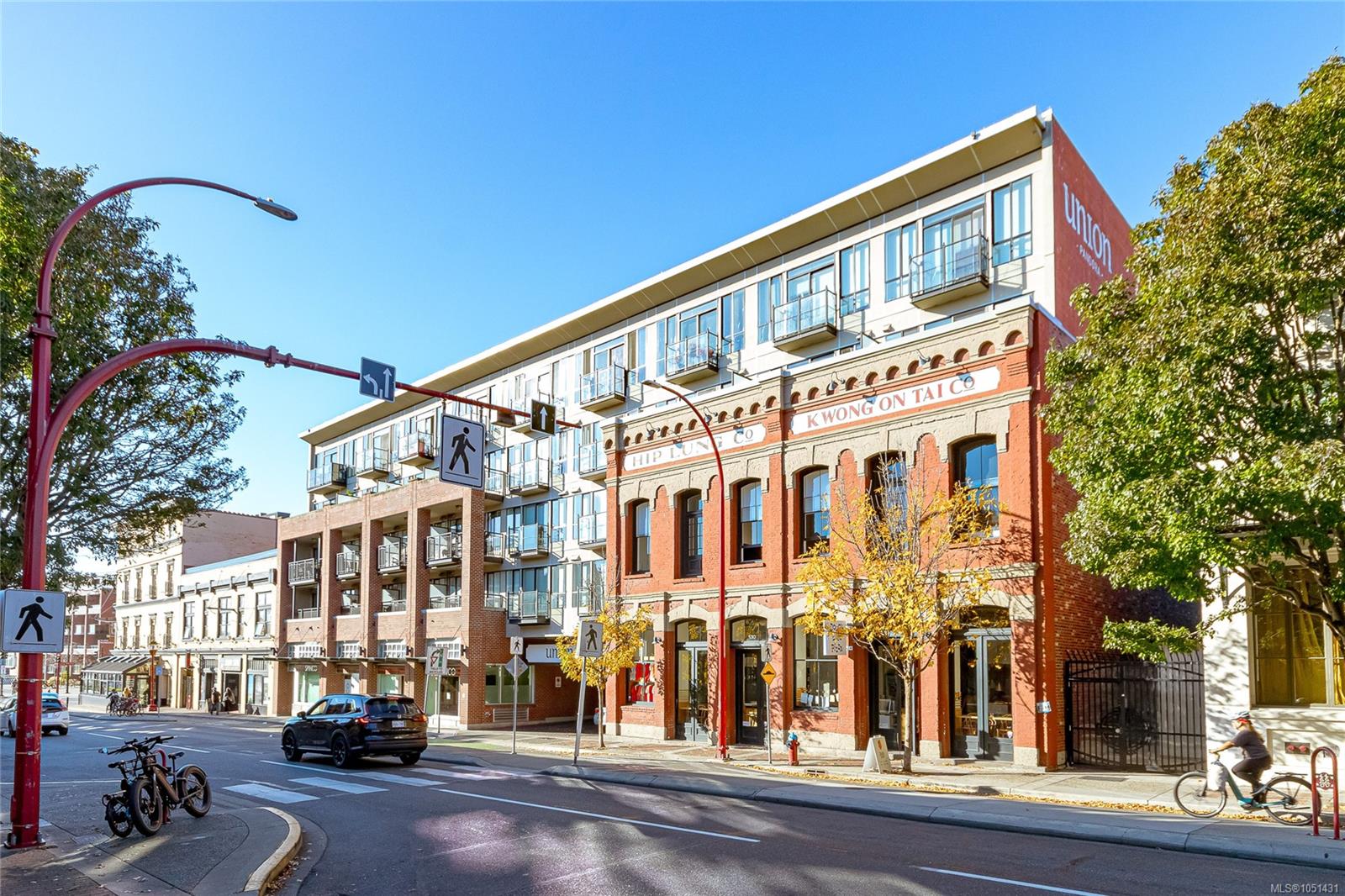 Street view of Union condominium above a historic brick storefront on Fisgard Street.