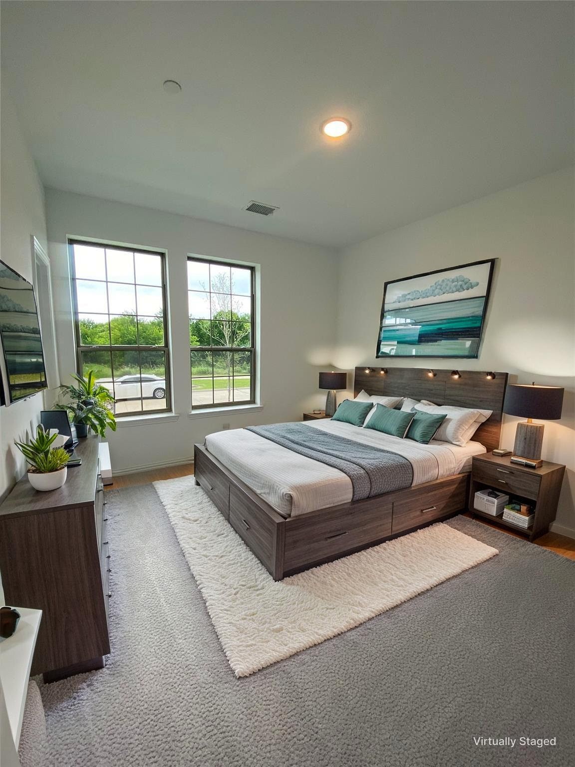 Staged bedroom with a wood platform bed, teal accents, and two tall windows.