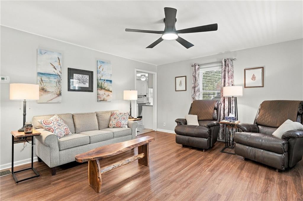Living room with a gray sofa, two leather recliners, and a wood coffee table.