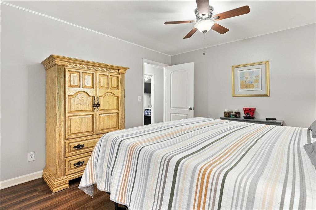 Bedroom with a striped bedspread and ornate wooden armoire.