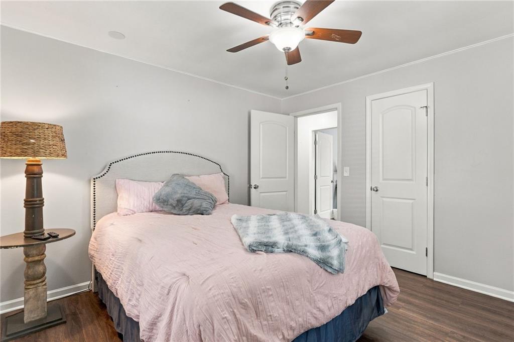 Bedroom with a pink bed, tufted headboard, and ceiling fan.