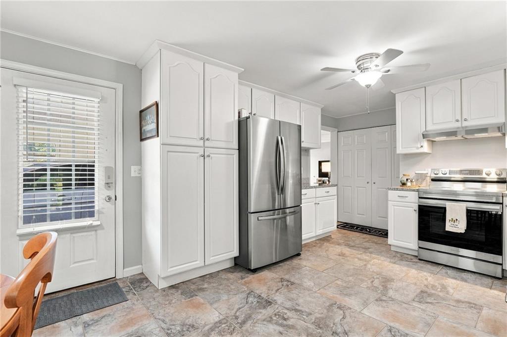 Kitchen with white cabinets, stainless steel appliances, and a tiled floor.