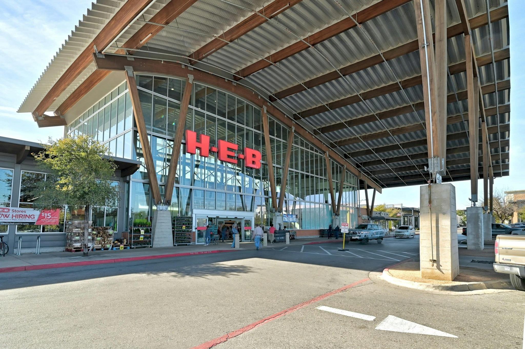 H-E-B grocery store entrance beneath a broad timber-and-metal canopy.