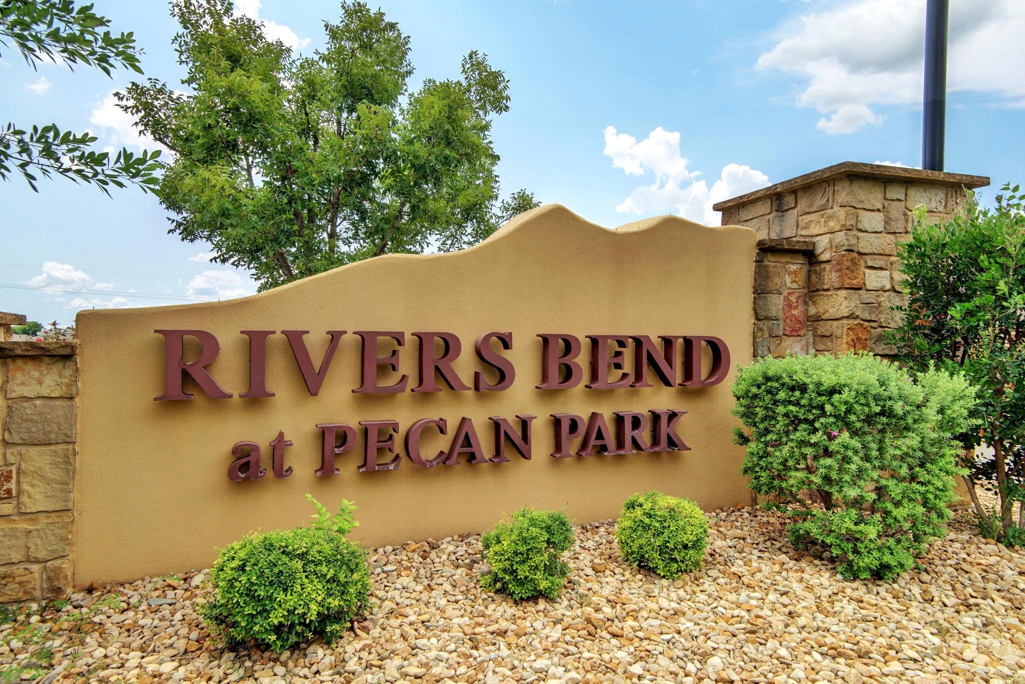 Rivers Bend at Pecan Park entrance sign, framed by stone pillars and landscaping.