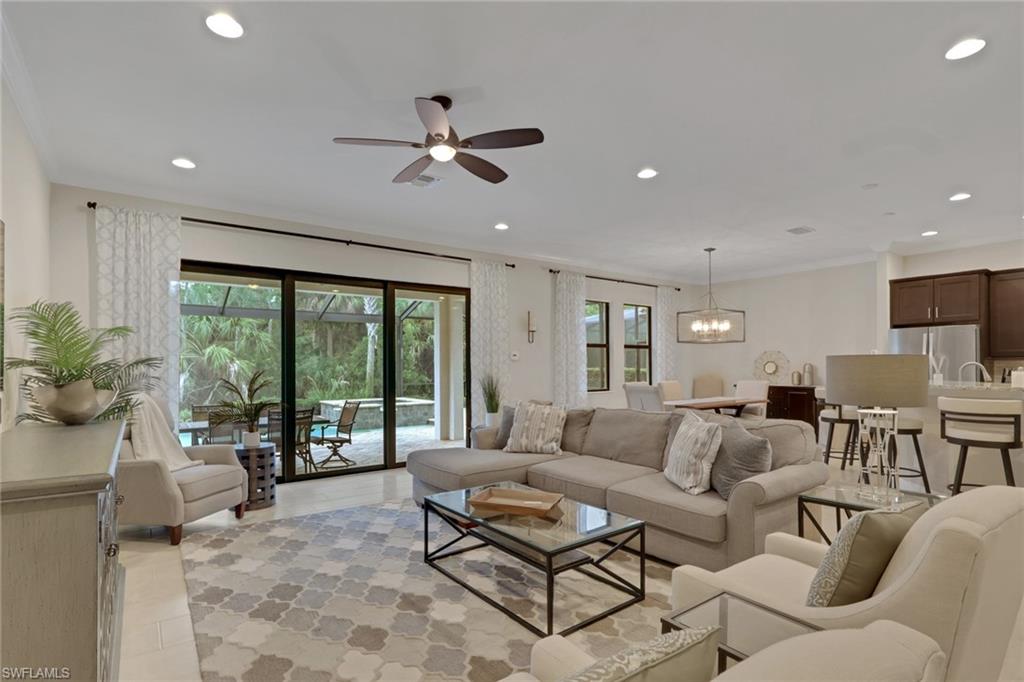 Open-plan living room with a large sectional, patterned rug, and sliding doors to the patio.