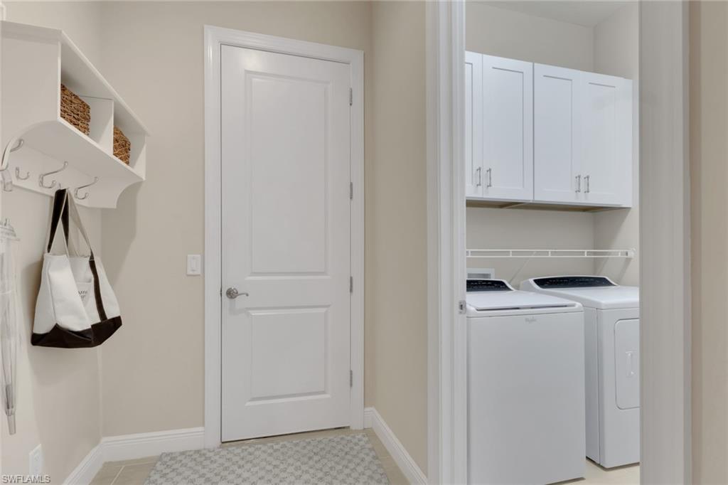Mudroom with wall hooks and storage cubbies beside a laundry room with washer and dryer.