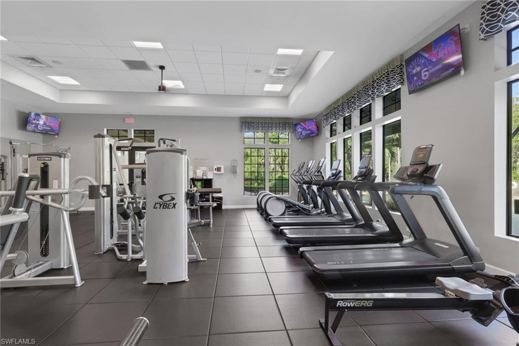 Fitness center with treadmills, weight machines, and large windows.