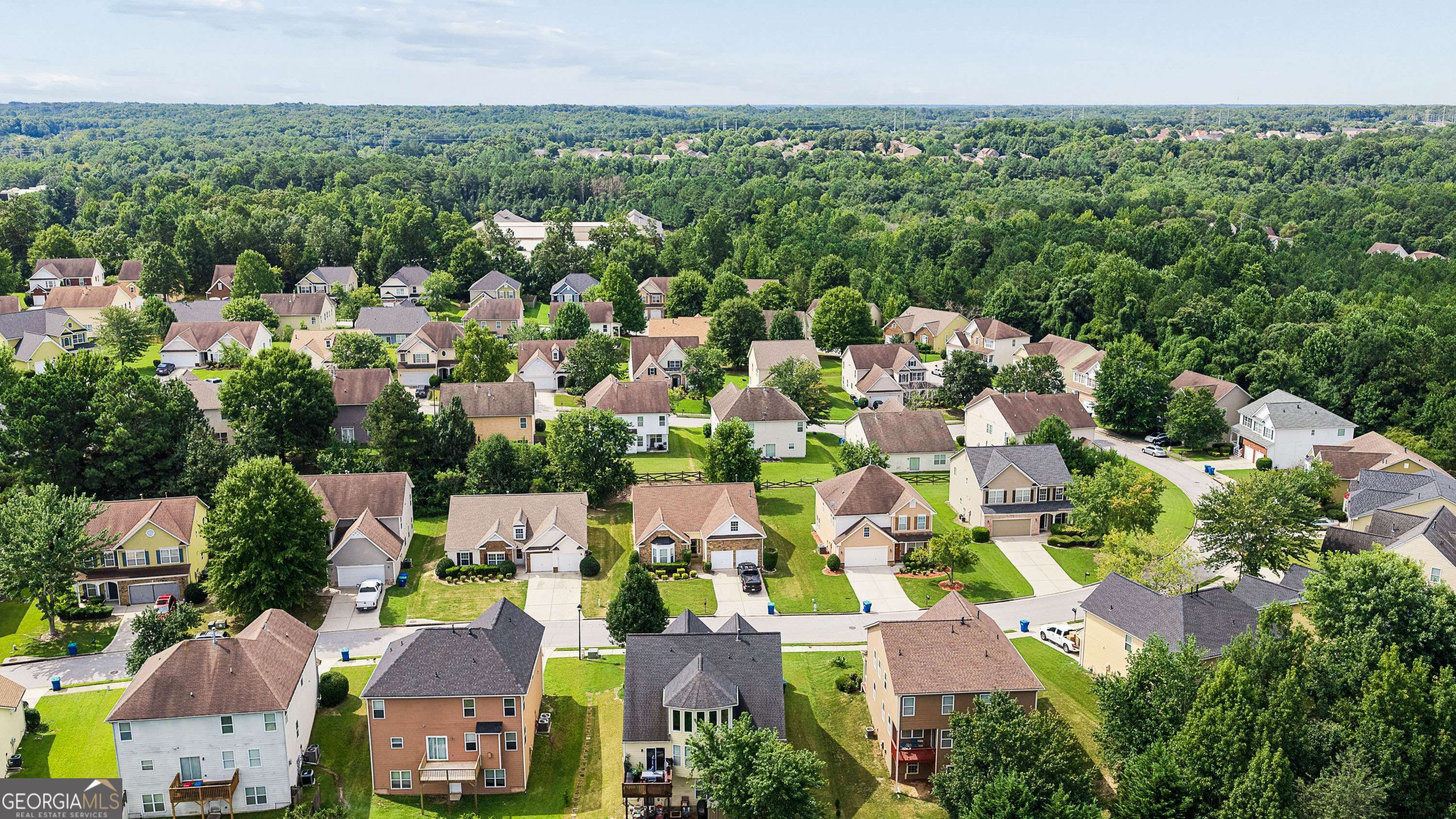 Aerial view of a residential neighborhood bordered by dense woods.