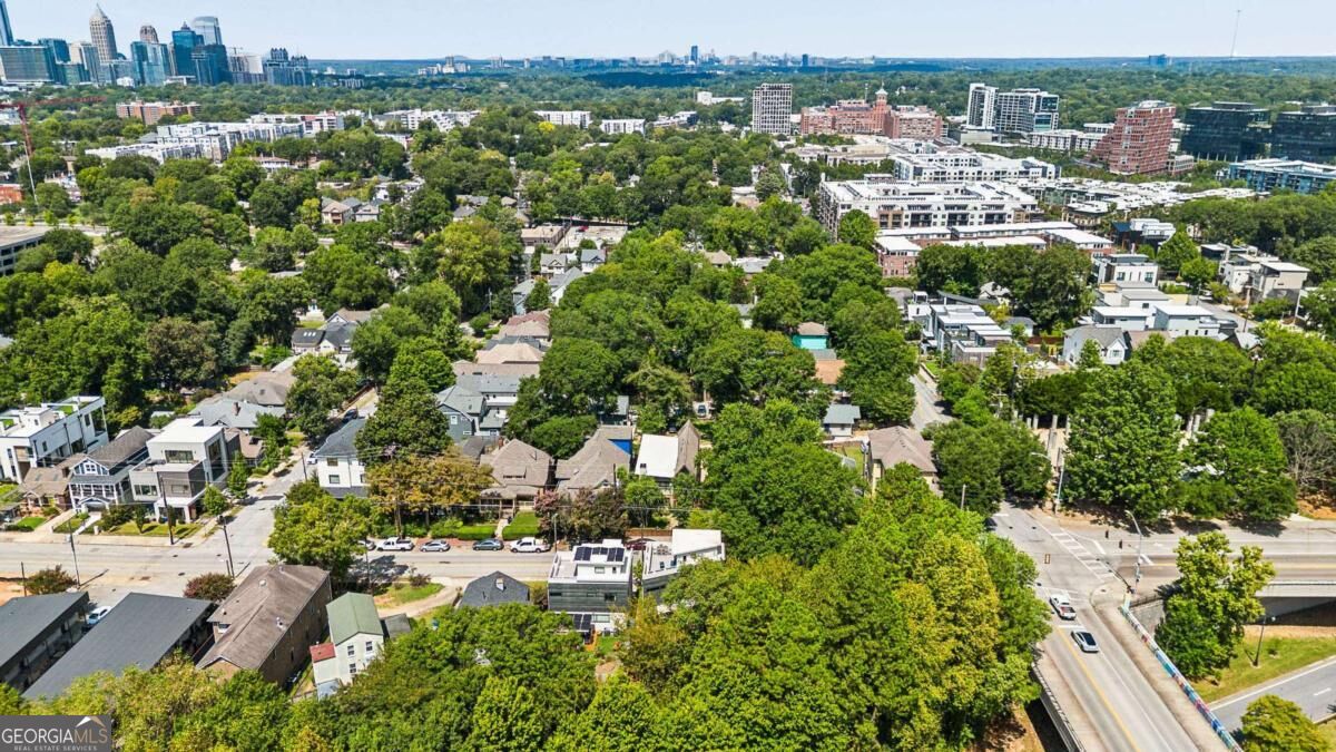 Aerial view of an Atlanta neighborhood and downtown skyline, with tree-lined streets and homes.