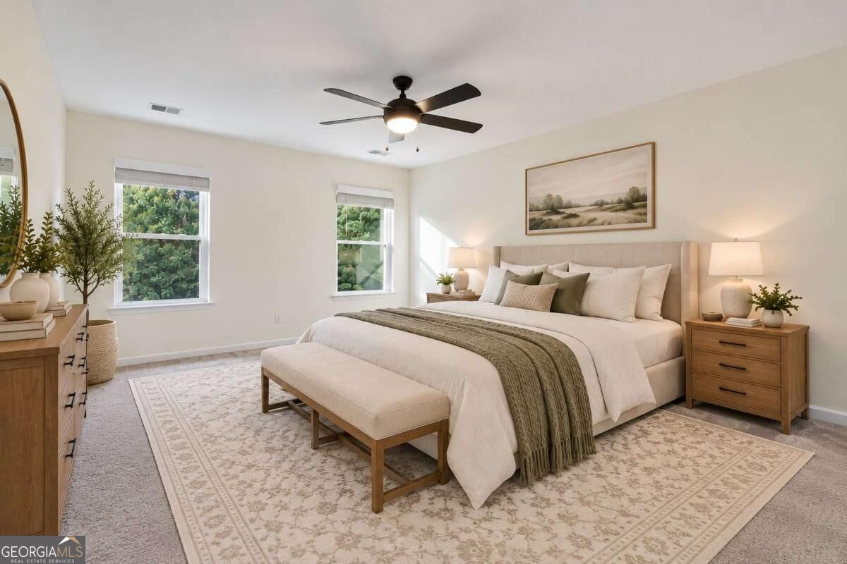 Staged bedroom with a king-size bed, matching wooden nightstands, and a ceiling fan.