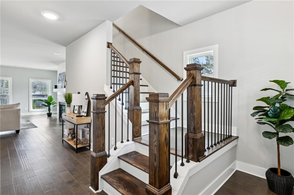 Interior staircase with dark wood steps, chunky newel posts, and black metal balusters.