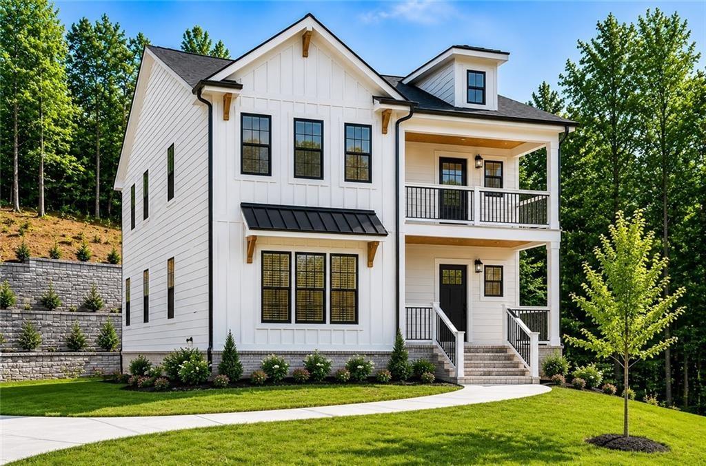 White two-story farmhouse with a covered balcony, black-framed windows, and landscaped lawn.