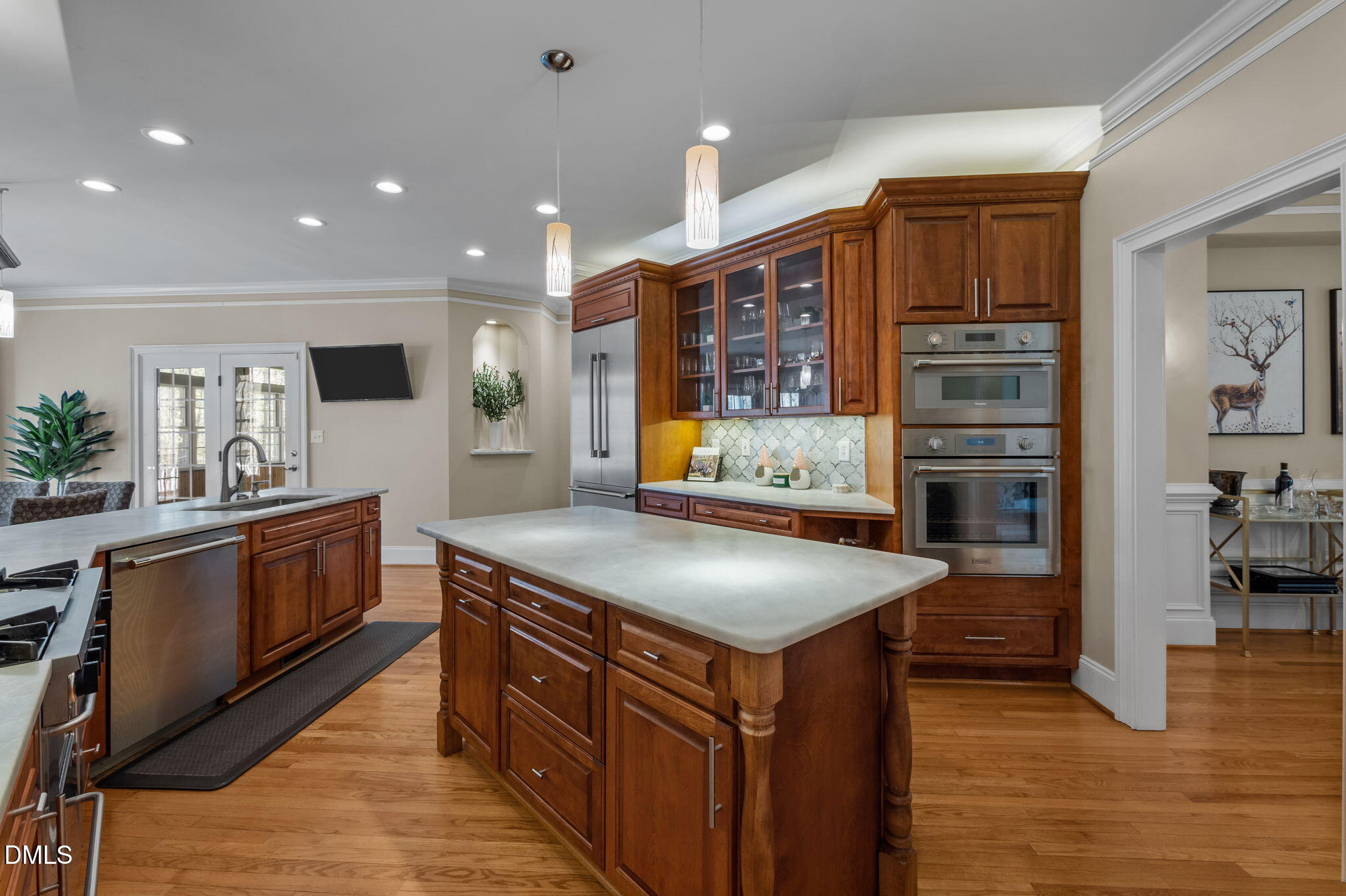 Kitchen with cherry-wood cabinetry, a large island, and stainless steel double ovens.