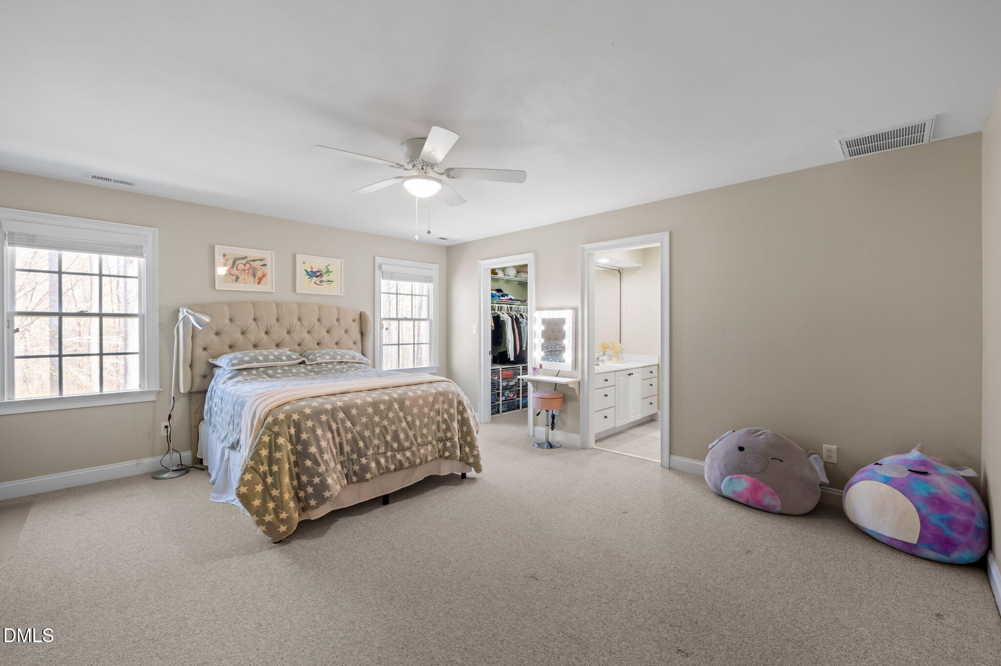 Bedroom with star-patterned bedding, two windows, an open closet, and an adjoining bathroom vanity.