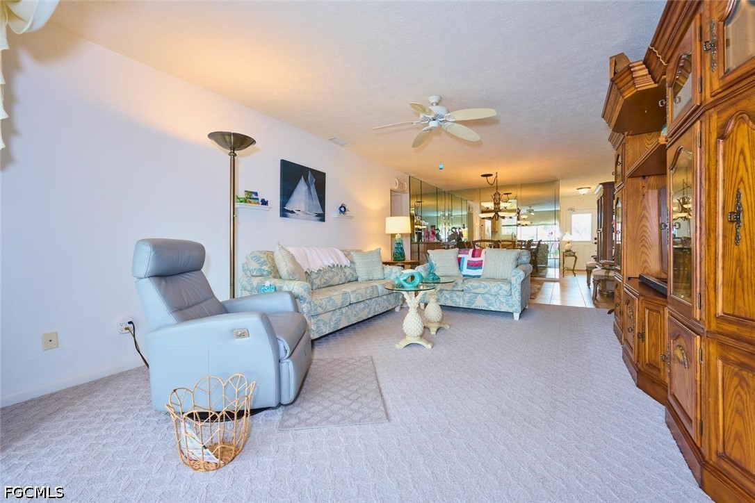 Furnished living room with pale sectional, recliner, and extensive wooden display cabinetry.