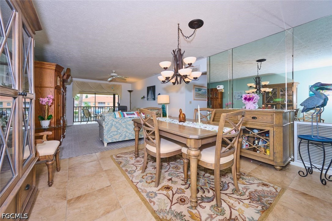 Condo dining area with a wooden table, mirrored wall, and sliding doors to a balcony.