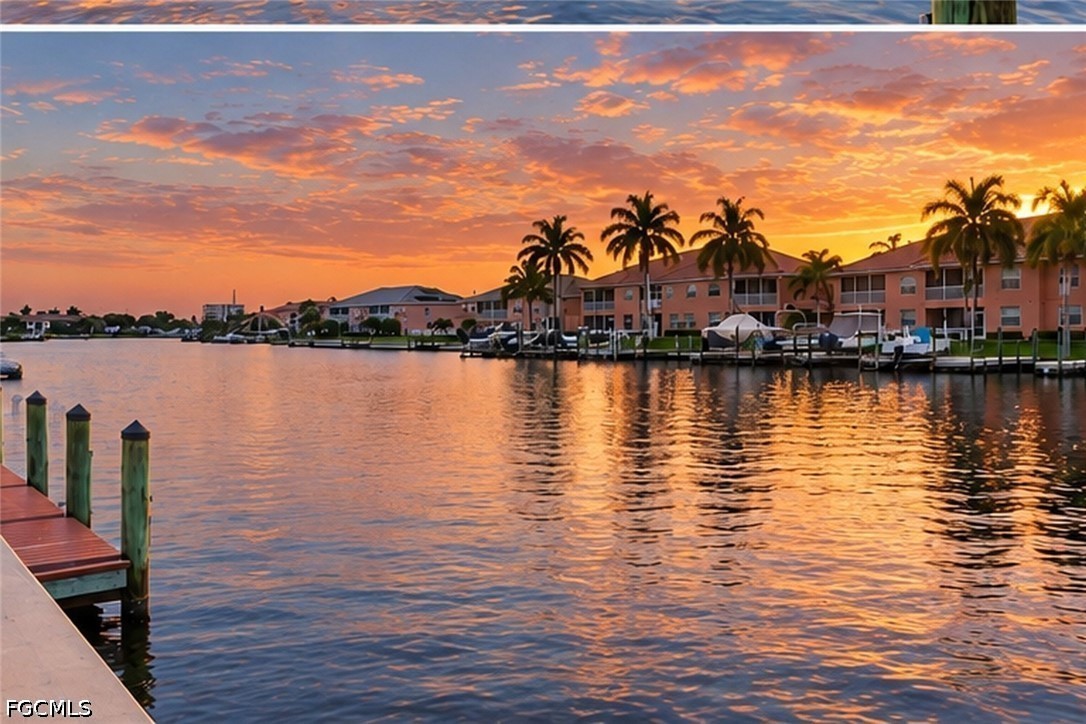 Waterfront condos and boat docks across a canal beneath a colorful sunset.