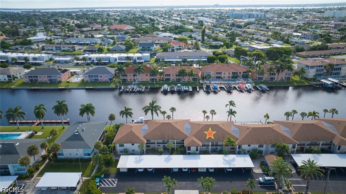 Aerial view of canal-front condominium buildings, with a star marking the featured unit.
