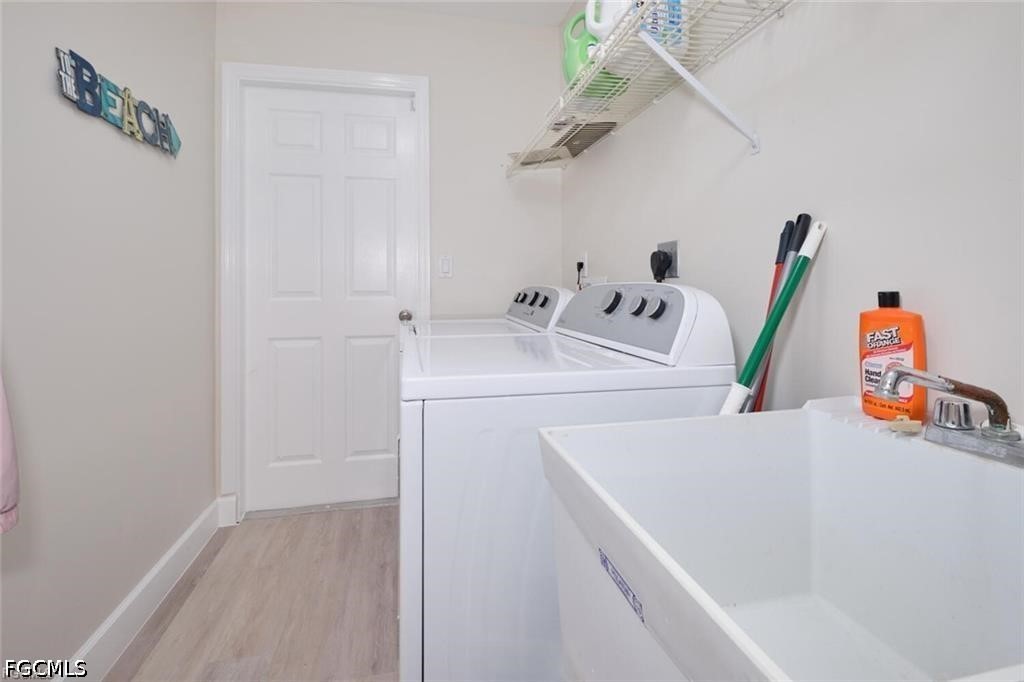 Laundry room with washer and dryer beside a large white utility sink.