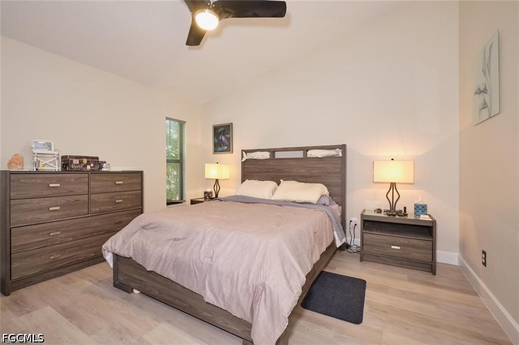 Furnished bedroom with a large bed, matching wood-tone furniture, and a ceiling fan.
