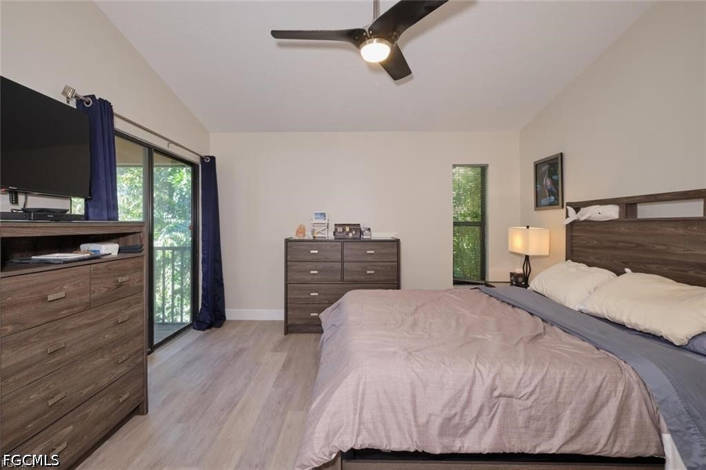 Bedroom with a dark wood bed and dressers, ceiling fan, and sliding glass door with blue curtains.