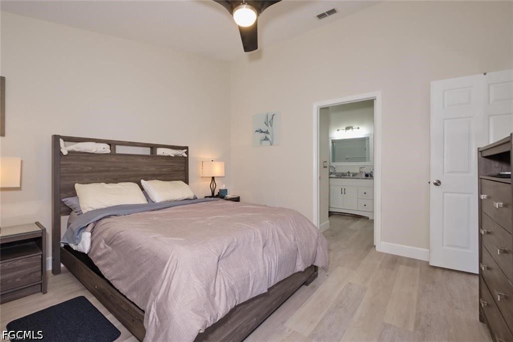Bedroom with a dark wood bed, pale bedding, and an open doorway to the bathroom.