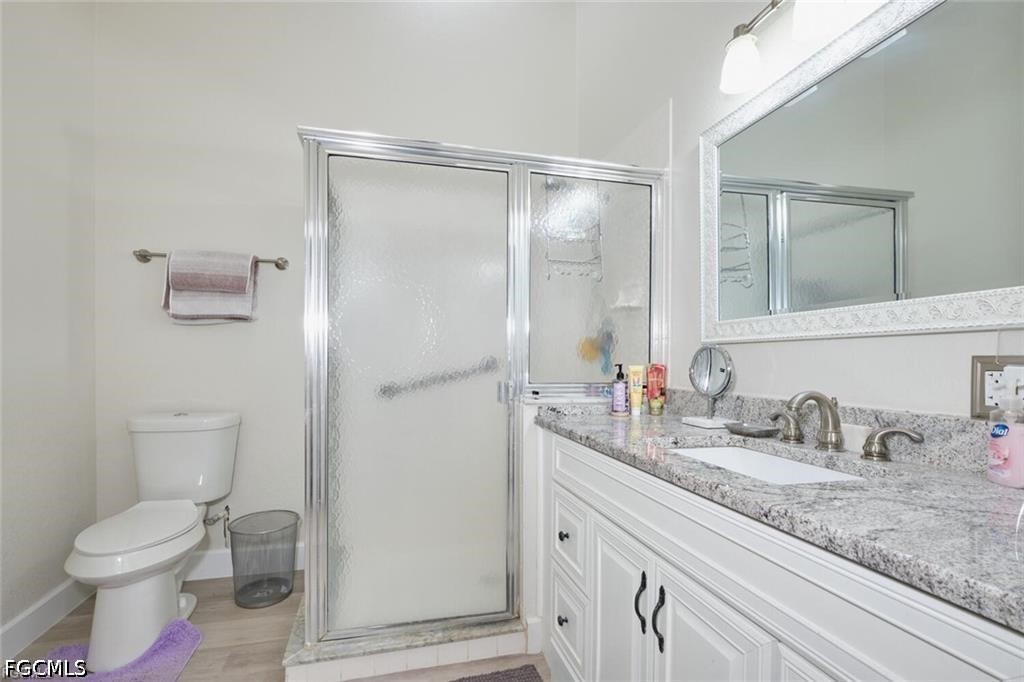 Bathroom with a frosted-glass shower and long double-sink vanity.