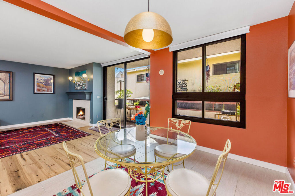 Dining area with a round glass table, woven chairs, and sliding doors to a small patio.