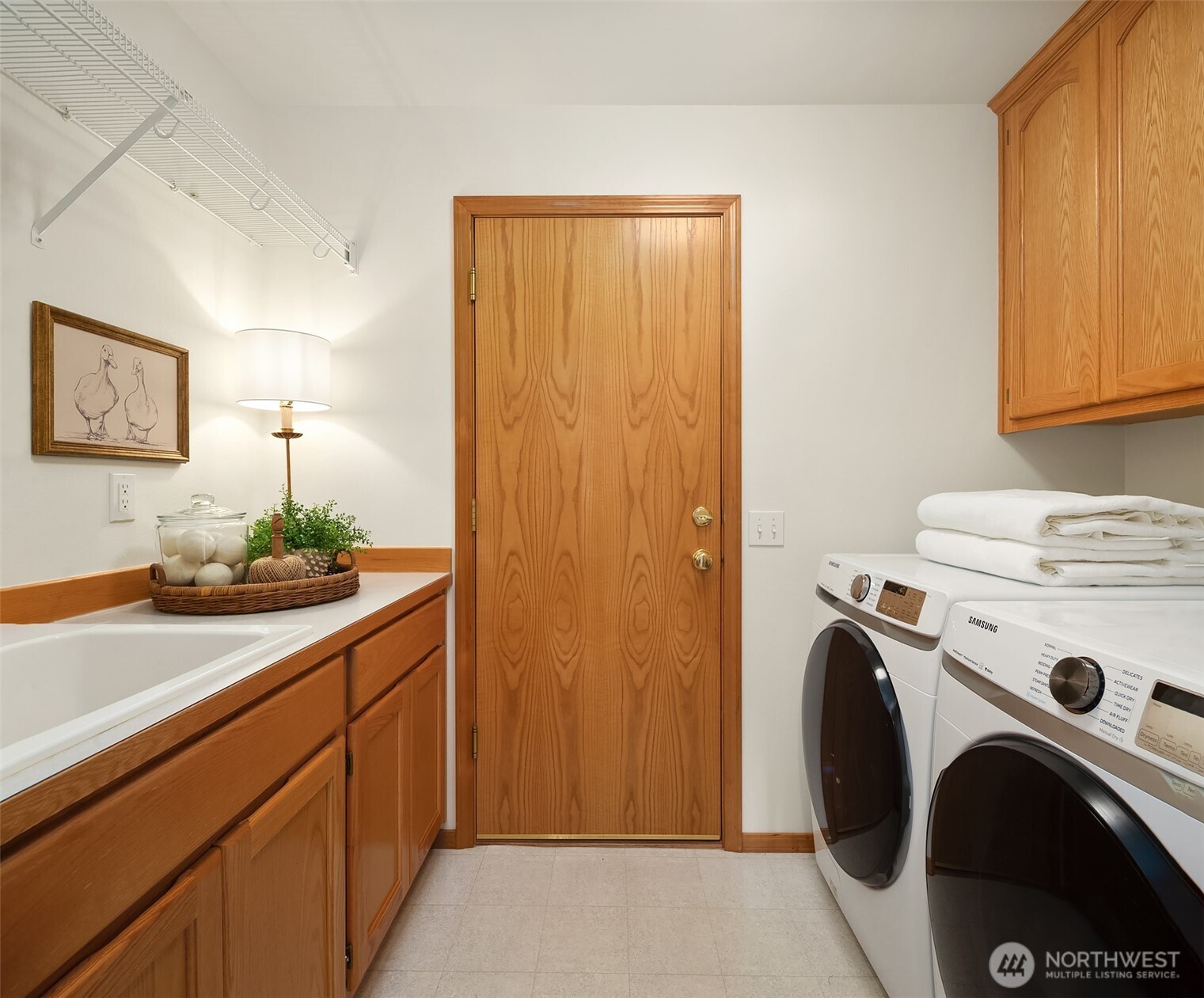 Laundry room with wood cabinetry, a utility sink, and side-by-side washer and dryer.