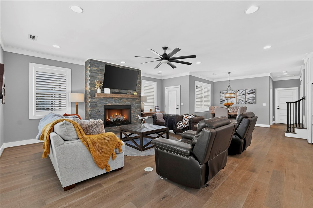 Furnished living room with a stone fireplace, television, and seating around a coffee table.