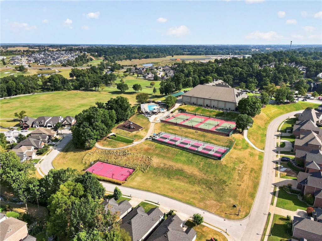 Aerial view of neighborhood amenities with tennis courts, a pool, playground, and basketball court.