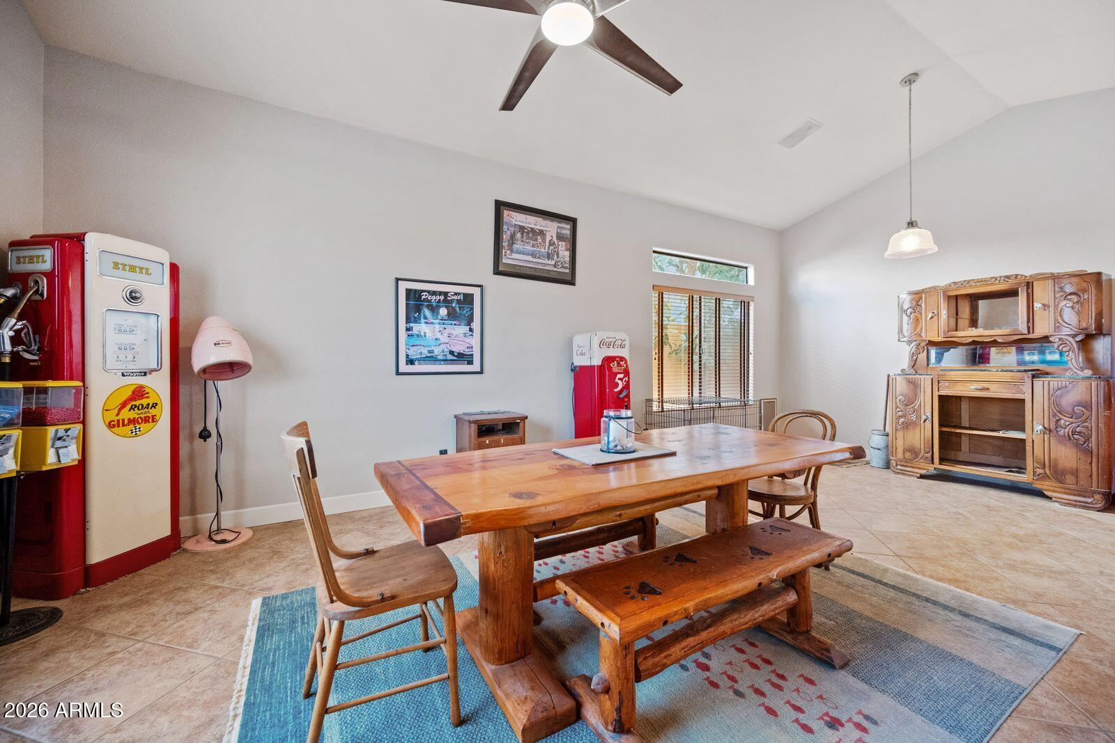 Dining room with a rustic wood table, vintage gas pumps, and an ornate wooden hutch.