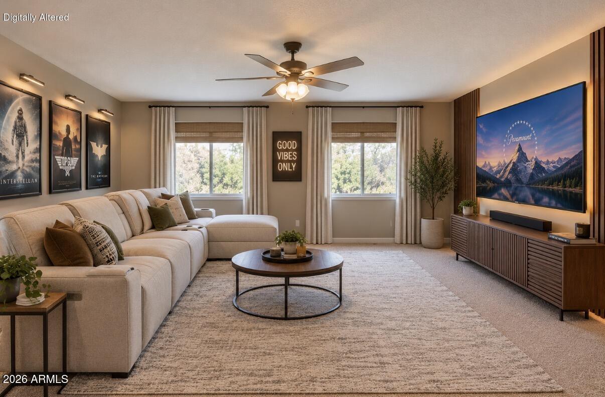 Staged living room with a cream sectional, round coffee table, and large wall-mounted television.