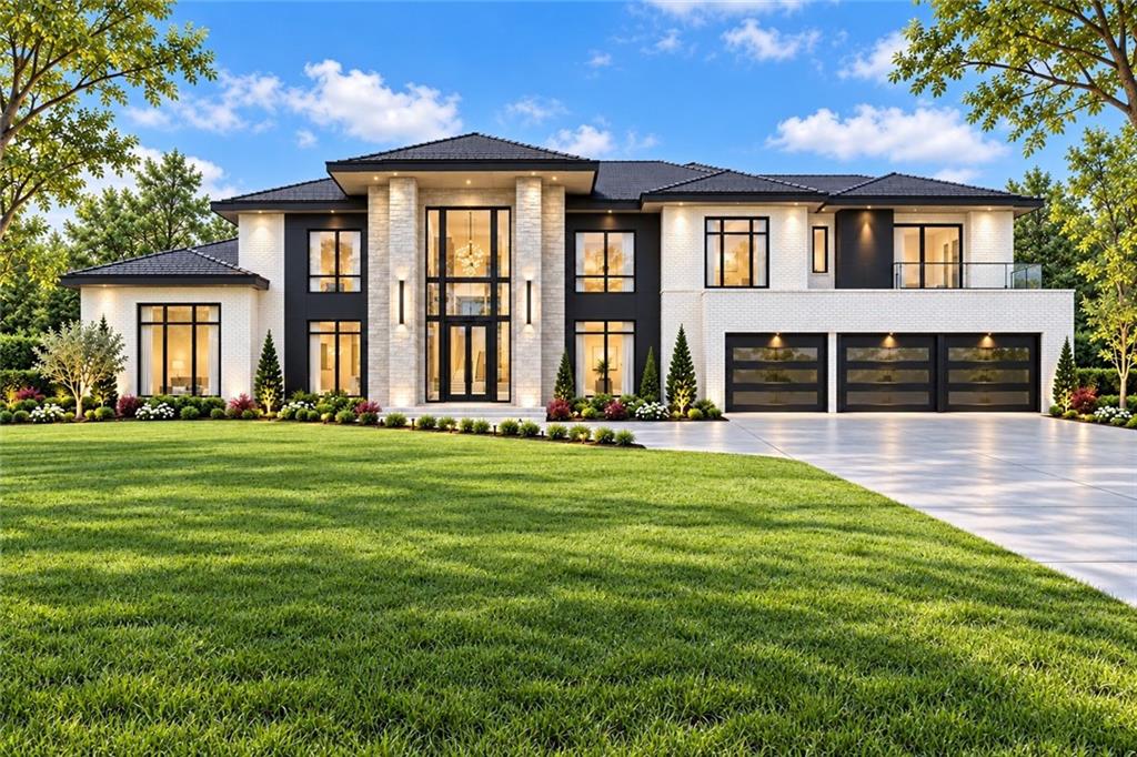 Modern two-story white-brick home with a central glass entry, three-car garage, and landscaped lawn.