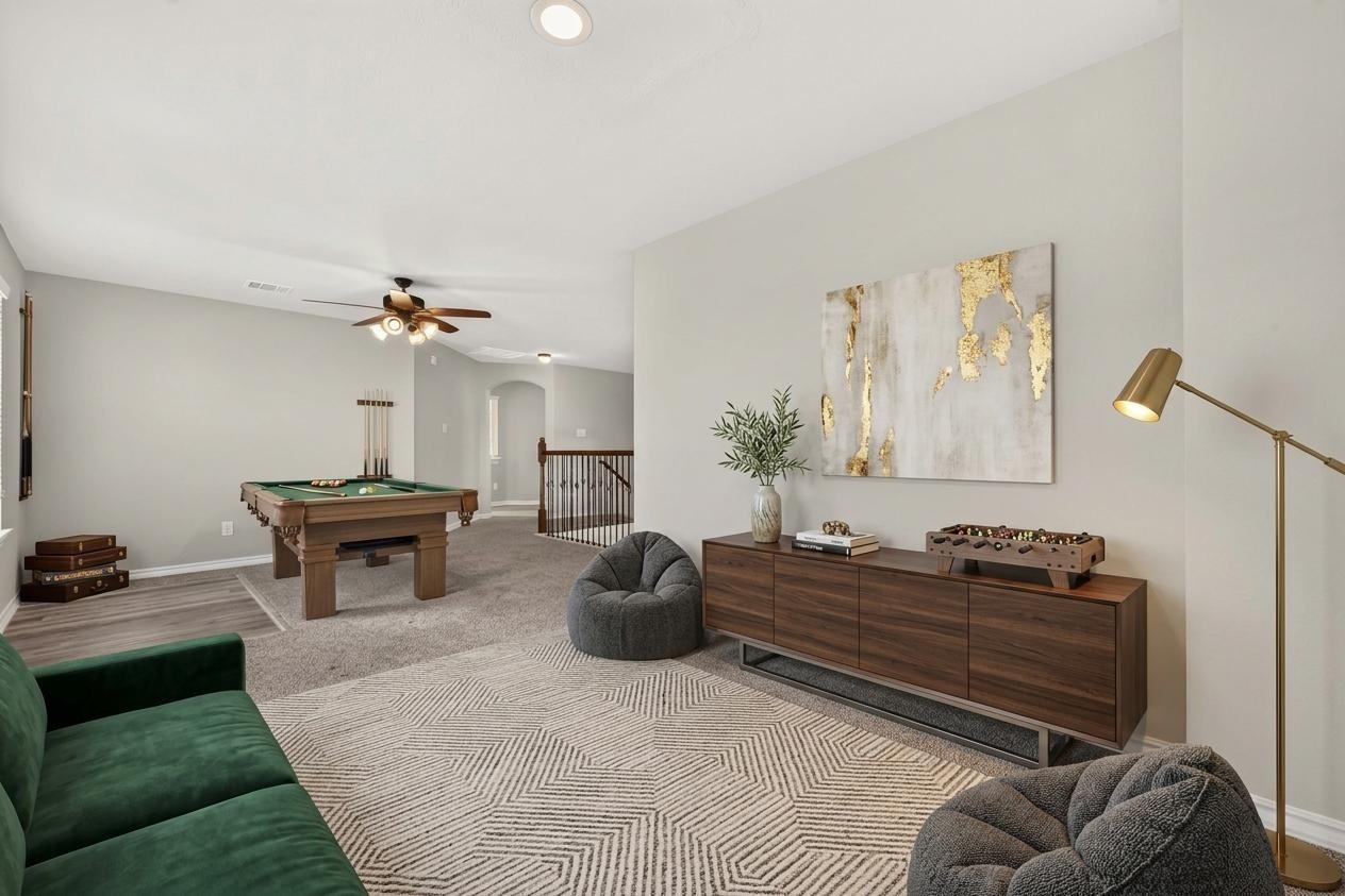 Game room with a pool table, green sofa, and walnut console beneath abstract art