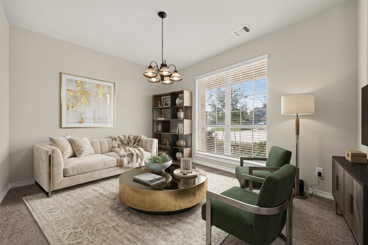 Staged living room with a cream sofa, green armchairs, and a round brass coffee table.