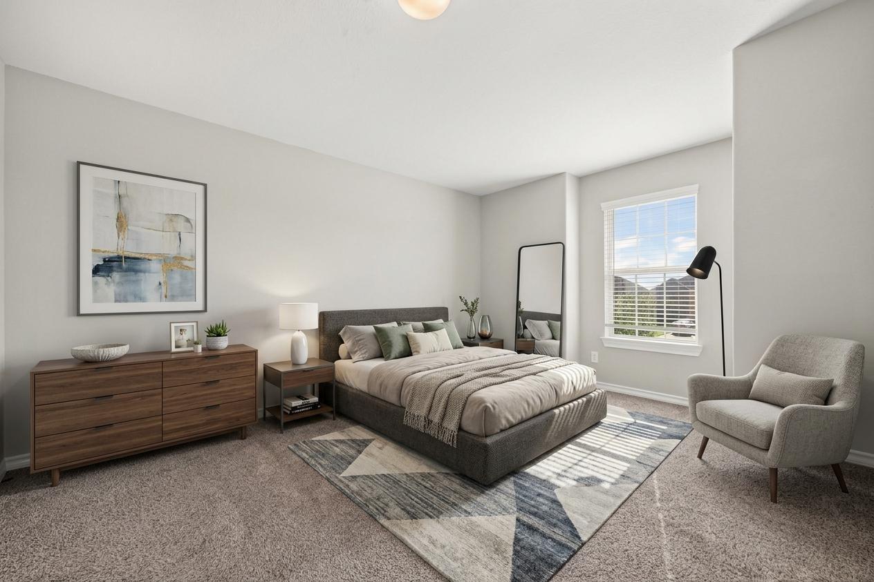 Staged bedroom with a gray upholstered bed, wooden dresser, and geometric rug.