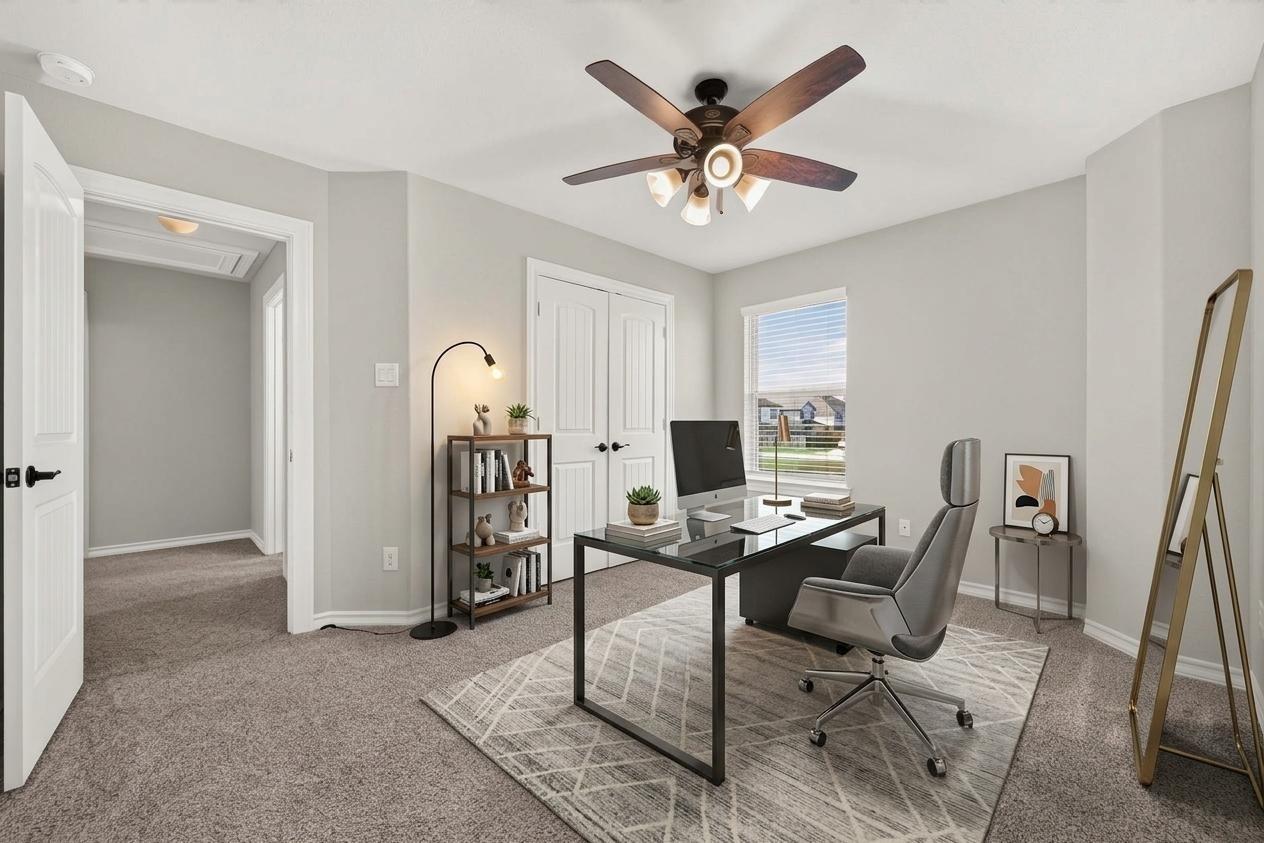 Furnished home office with a glass-top desk, gray swivel chair, and window overlooking neighboring homes.