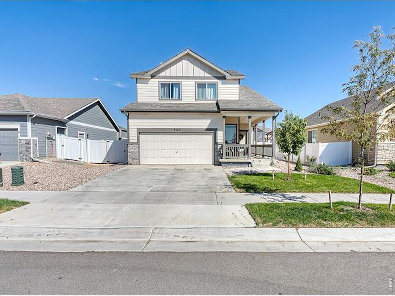 Two-story house with a double garage, covered porch, and small front lawn.