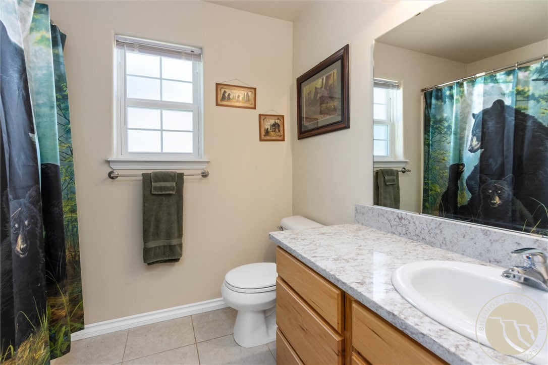 Bathroom with a wood vanity, large mirror, and bear-print shower curtain.