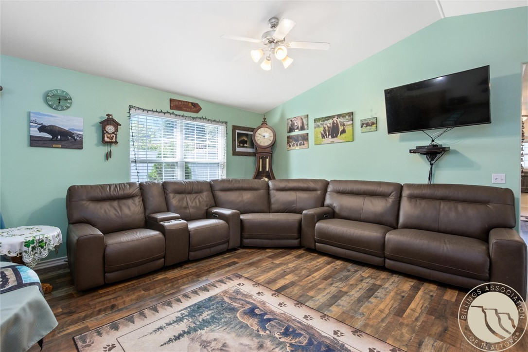 Living room with a brown leather sectional, mint-green walls, and a bear-patterned rug.