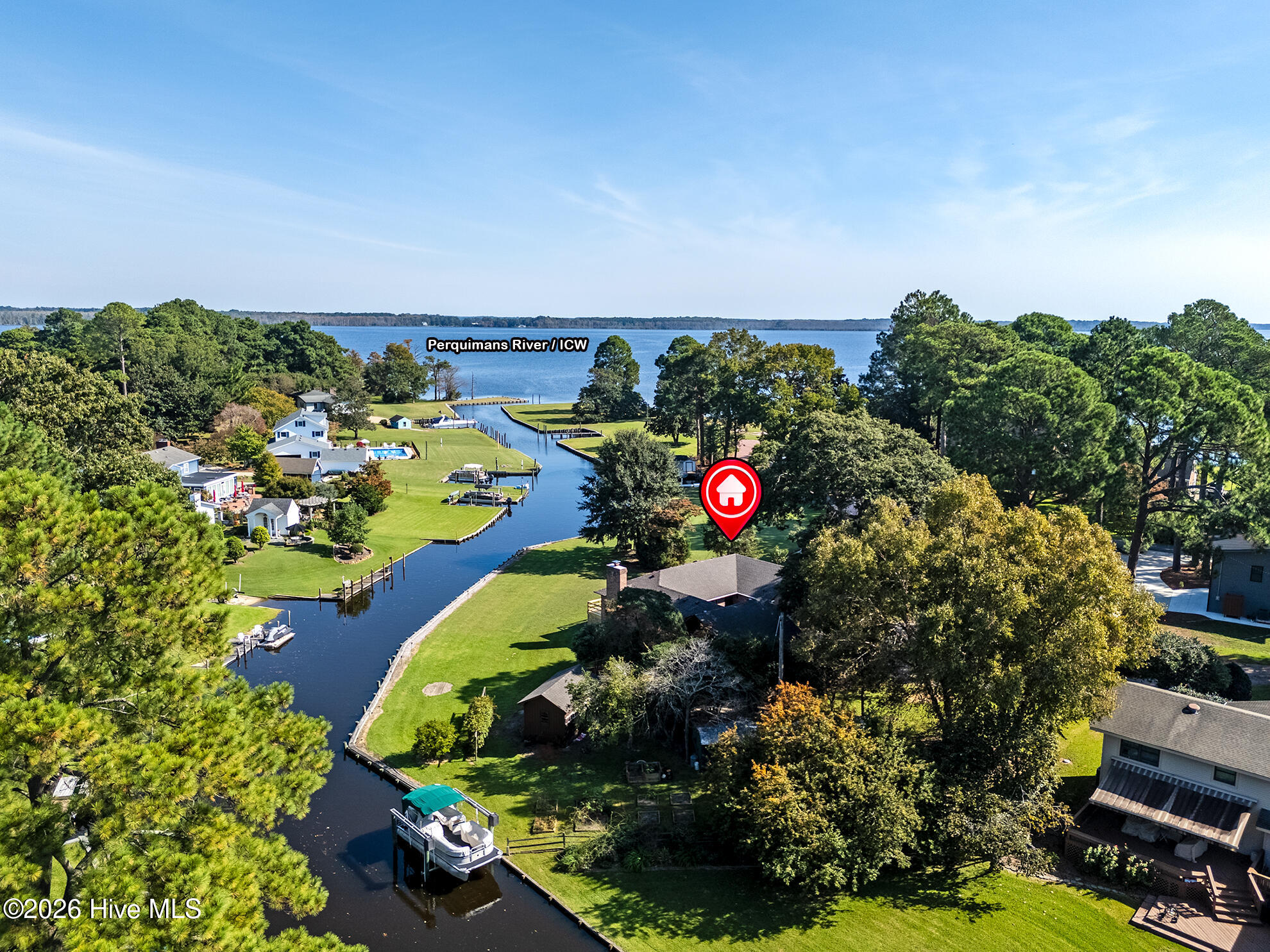 Waterfront home beside a canal, with a private dock and the Perquimans River beyond.
