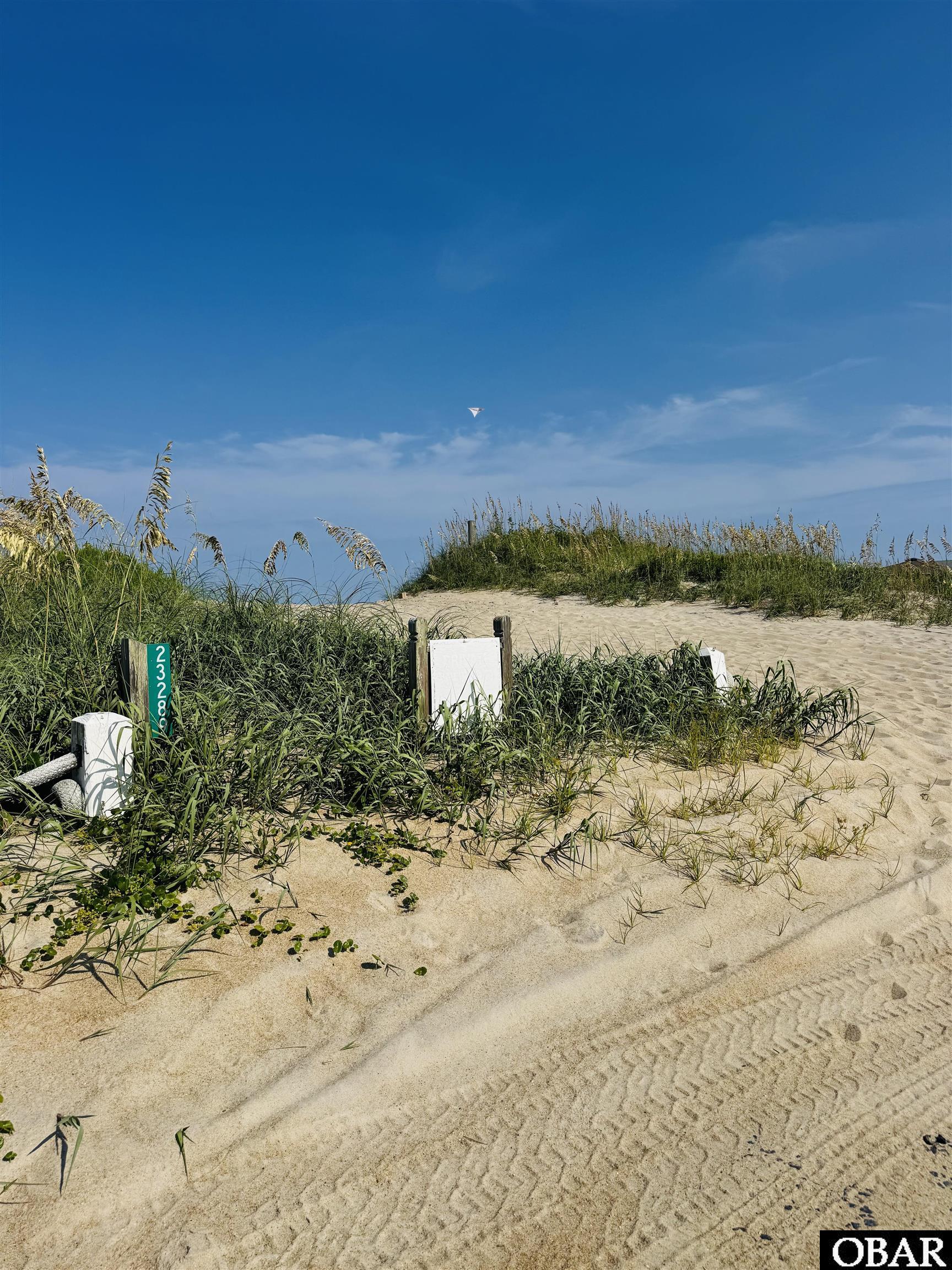 Sandy coastal lot marked 23289, with dune grass and a sandy access track.