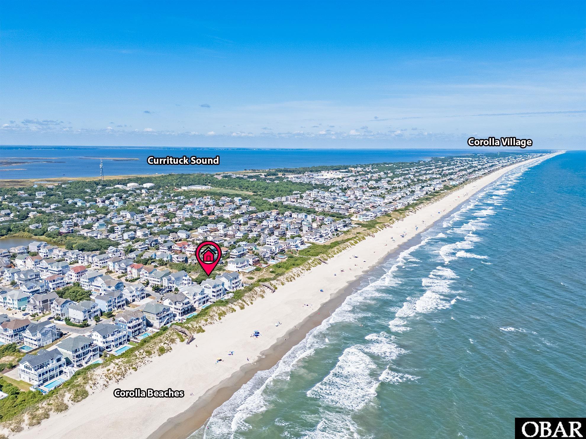 Aerial view of Corolla Beaches, with a pink marker locating a home between the ocean and Currituck Sound.