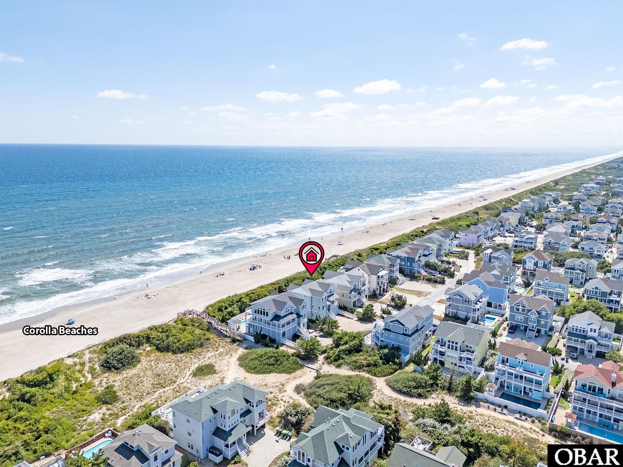 Aerial view of Corolla beachfront homes, with a location marker beside the ocean.