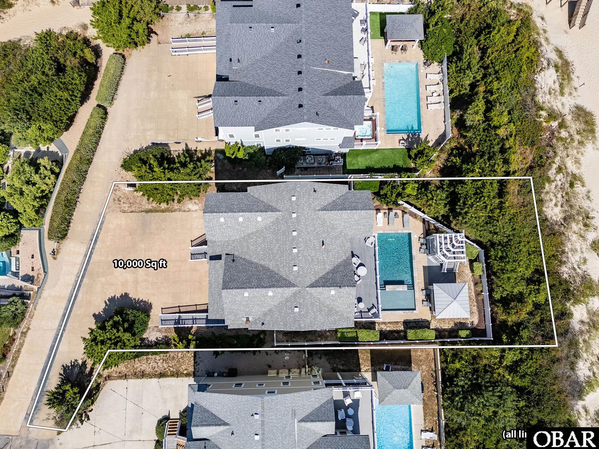Aerial view of 615 Tide Arch, with its outlined lot, home, and private pool.
