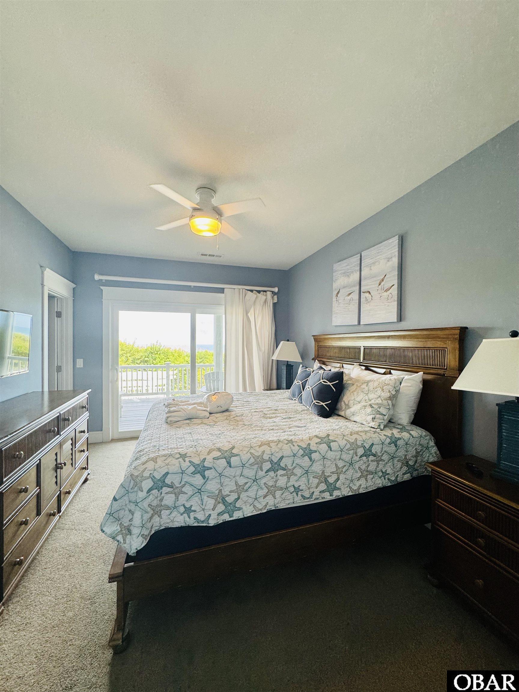 Bedroom with starfish-patterned bedding and sliding doors opening to a balcony.