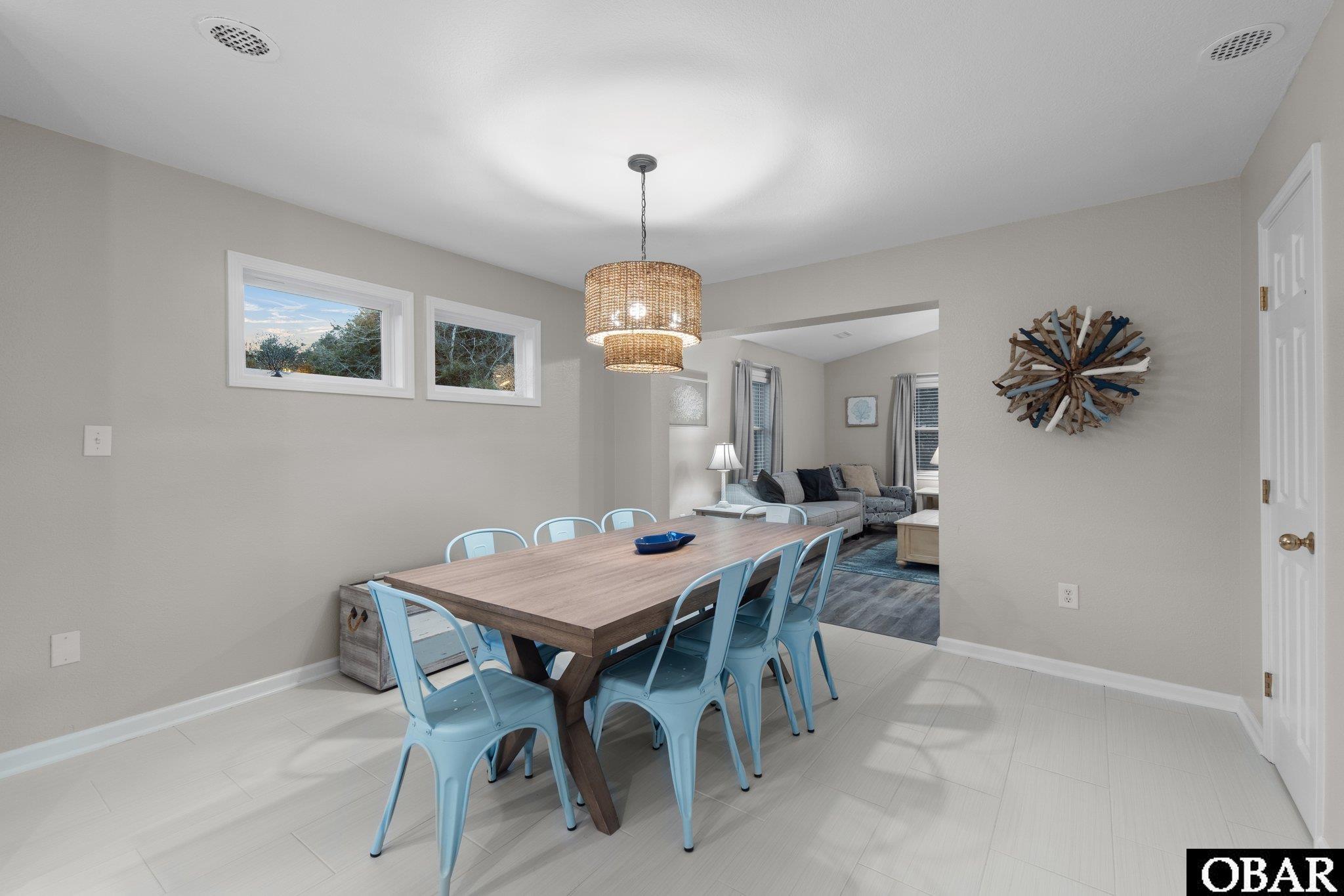 Dining room with a wood table, light blue chairs, and a woven pendant light.