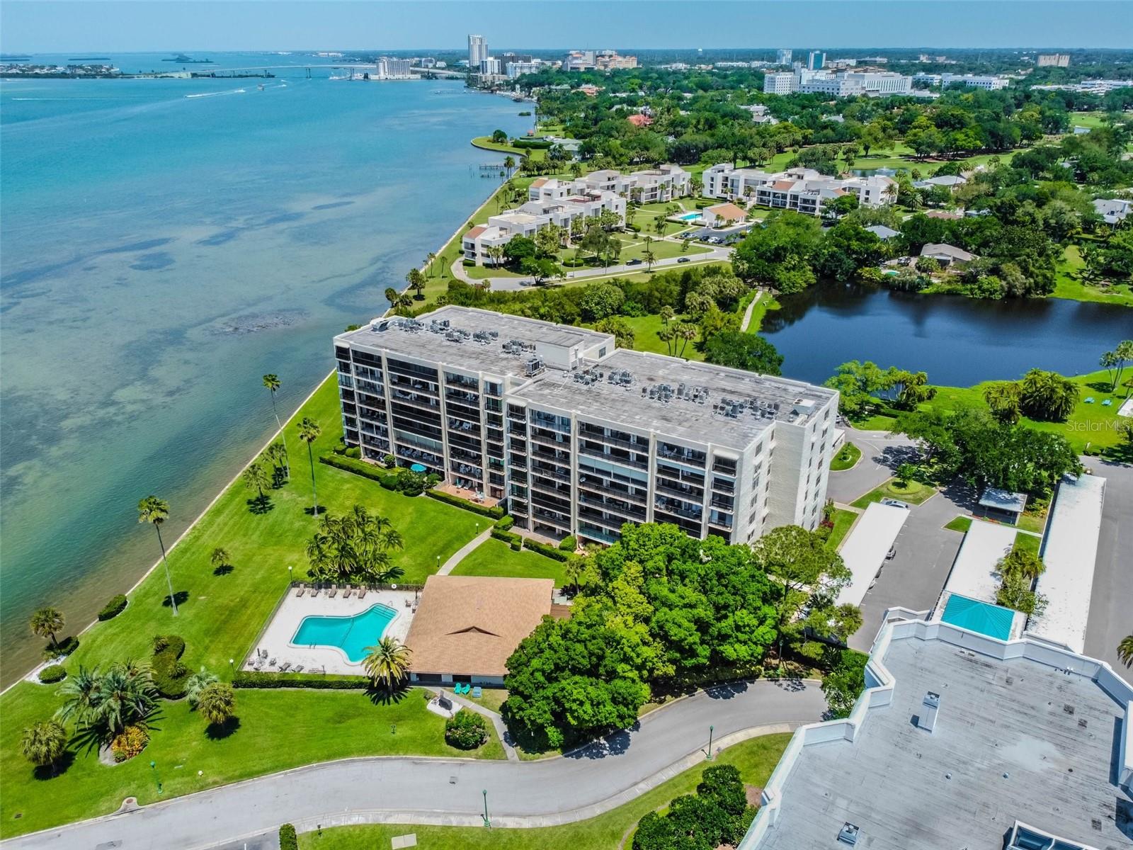 Waterfront condominium complex with a swimming pool beside the bay.